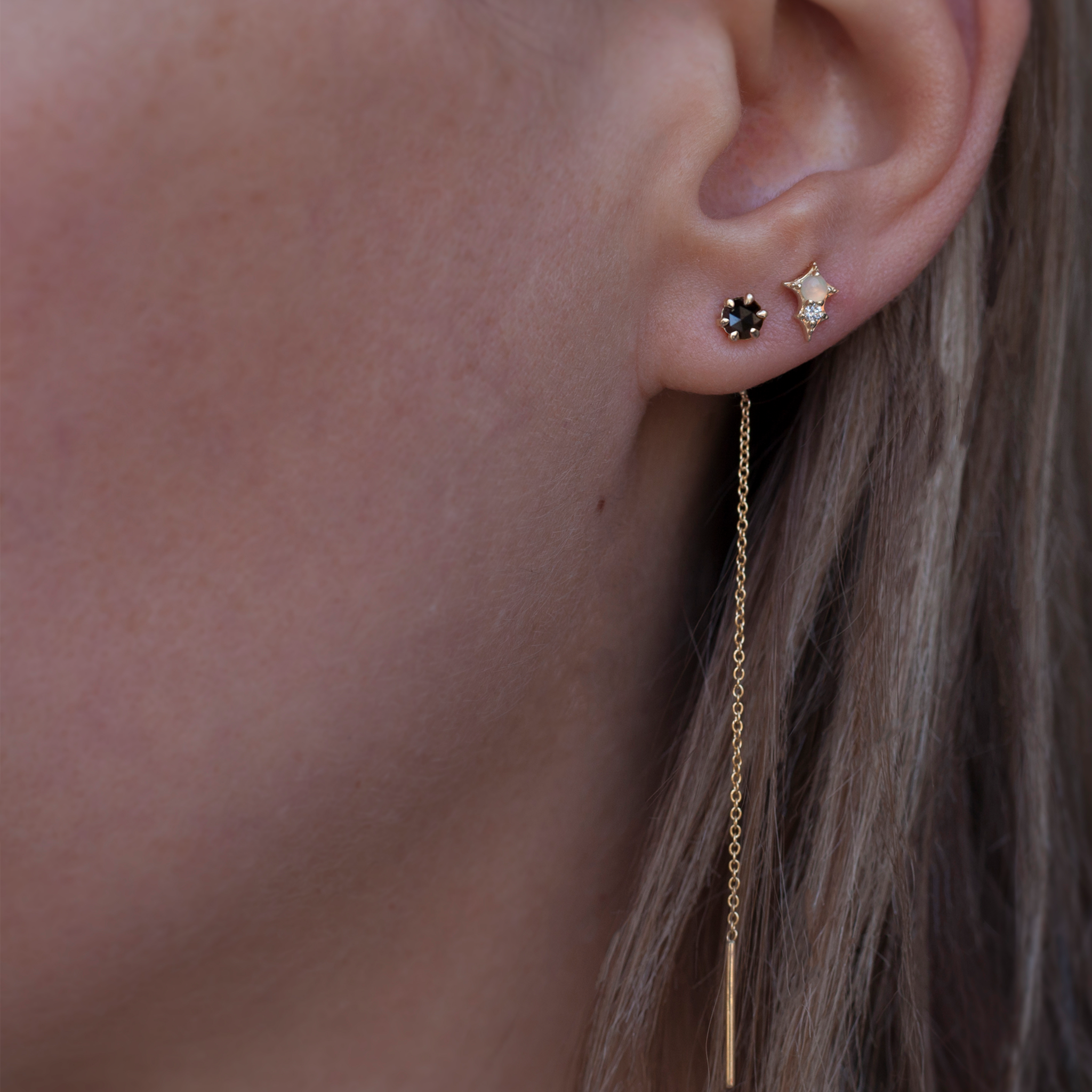 Delicate black round rose cut diamond threaders, ideal for threading through multiple piercings, feature a six claw prong setting, using 14k or 18k yellow gold.