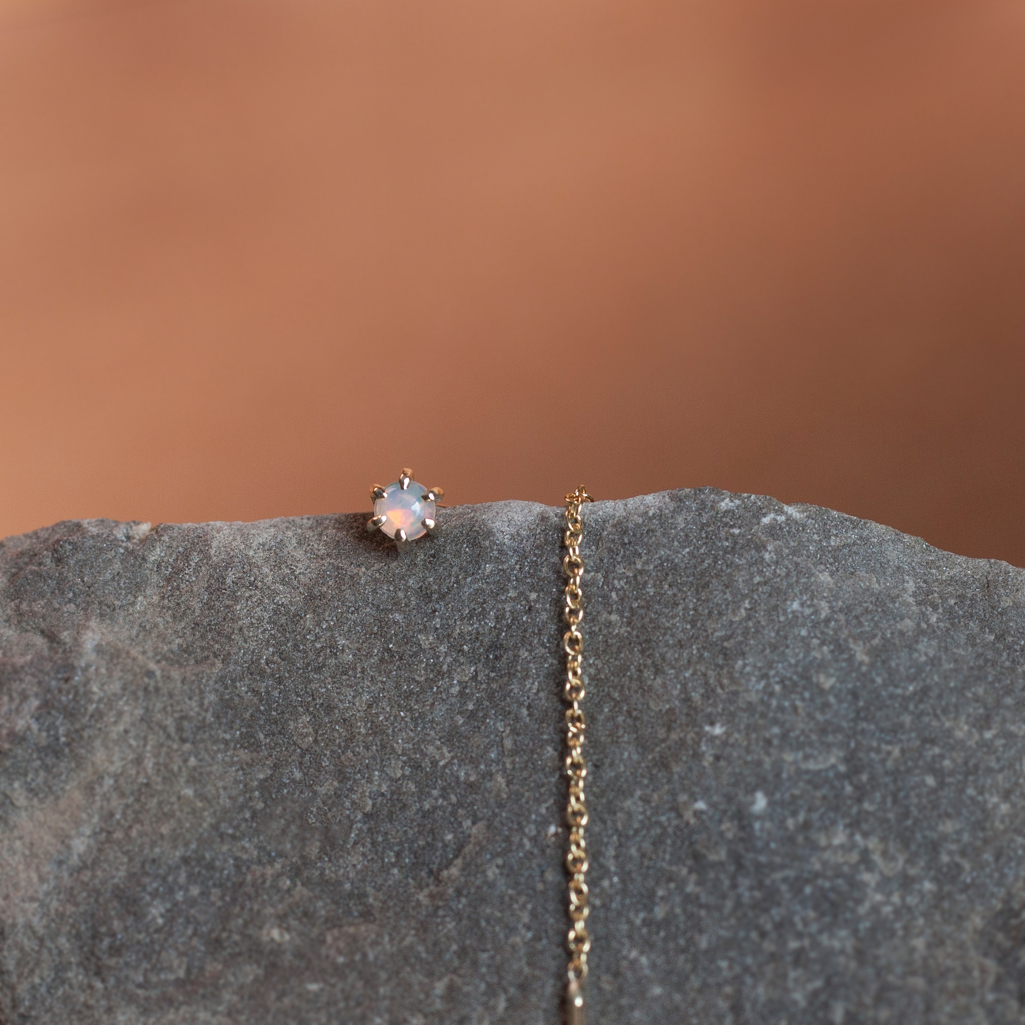 Delicate opal gold threaders, ideal for threading through multiple piercings, feature a six claw prong setting, using 14K gold.