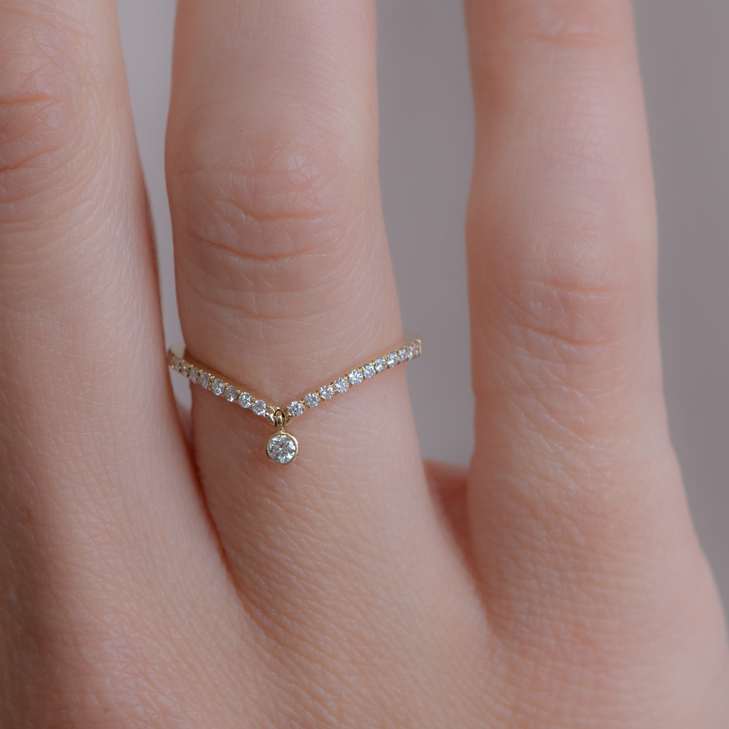 Delicate dangle wedding band, with chevron contour to trace and pair with any engagement ring, whether it’s a solitaire or a halo. This ring is also a perfect everyday stackable ring that can be stacked with your favourite everyday staples, or worn on its own. Made in 14K gold.