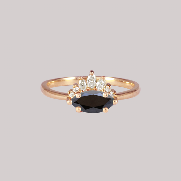 Contemporary take on a traditional marquise diamond ring features an East-West marquise black diamond. The centre stone is surrounded with a diamond crown of marquise and round brilliant diamonds. Made in solid 14k or 18K yellow gold.