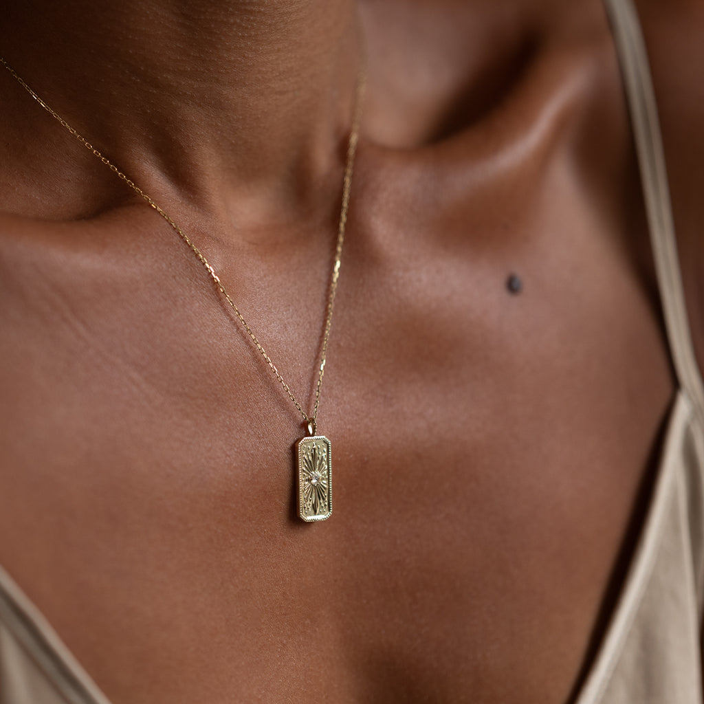 Personalized gold charm, for her, featuring a sun burst detail. The rectangular gold charm features a white rose cut diamond and is made in 14K or 18K yellow gold. 