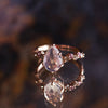 Unique pear shape moonstone engagement ring, on a cluster band, featuring pink sapphires and champagne diamonds. Made in 14k or 18k rose gold.