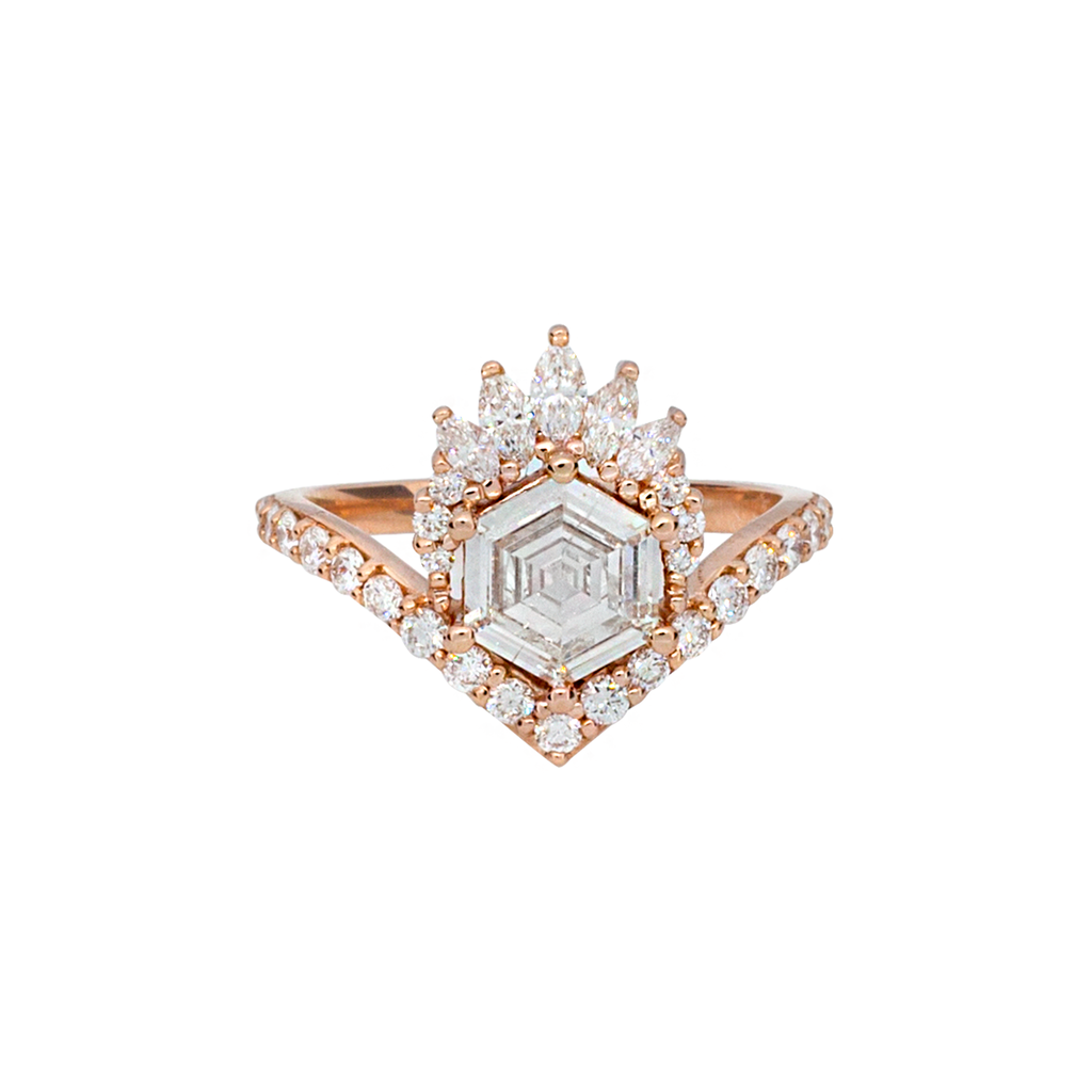 Unique step cut hexagon diamond engagement ring, featuring a delicate V shape band, encrusted with round brilliant diamonds. The hexagon step cut diamond has a low profile setting and is surrounded with a fine crown of marquise and round cut white diamonds. Made in 14k or 18k rose gold. 