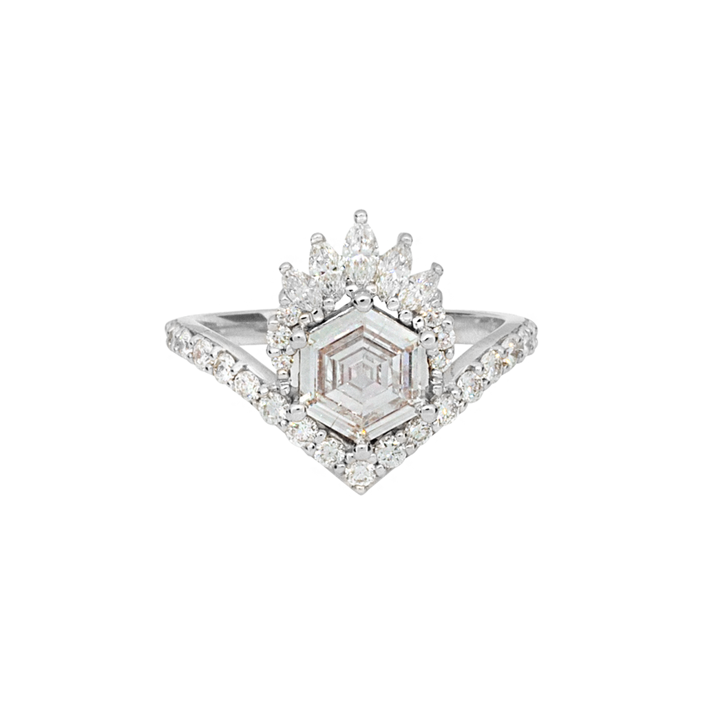 Unique step cut hexagon diamond engagement ring, featuring a delicate V shape band, encrusted with round brilliant diamonds. The hexagon step cut diamond has a low profile setting and is surrounded with a fine crown of marquise and round cut white diamonds. Made in 14k or 18k white gold. 