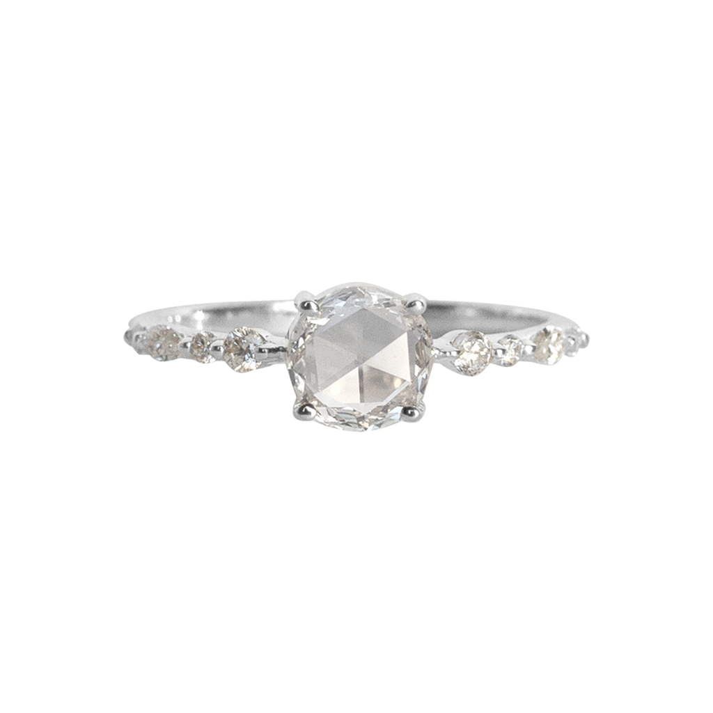 A twist on a classic solitaire engagement ring, featuring a round rose cut diamond, set with four prongs. The main diamond sits on maquise and round brilliant cut diamond band. Made in 14k or 18k white gold. 