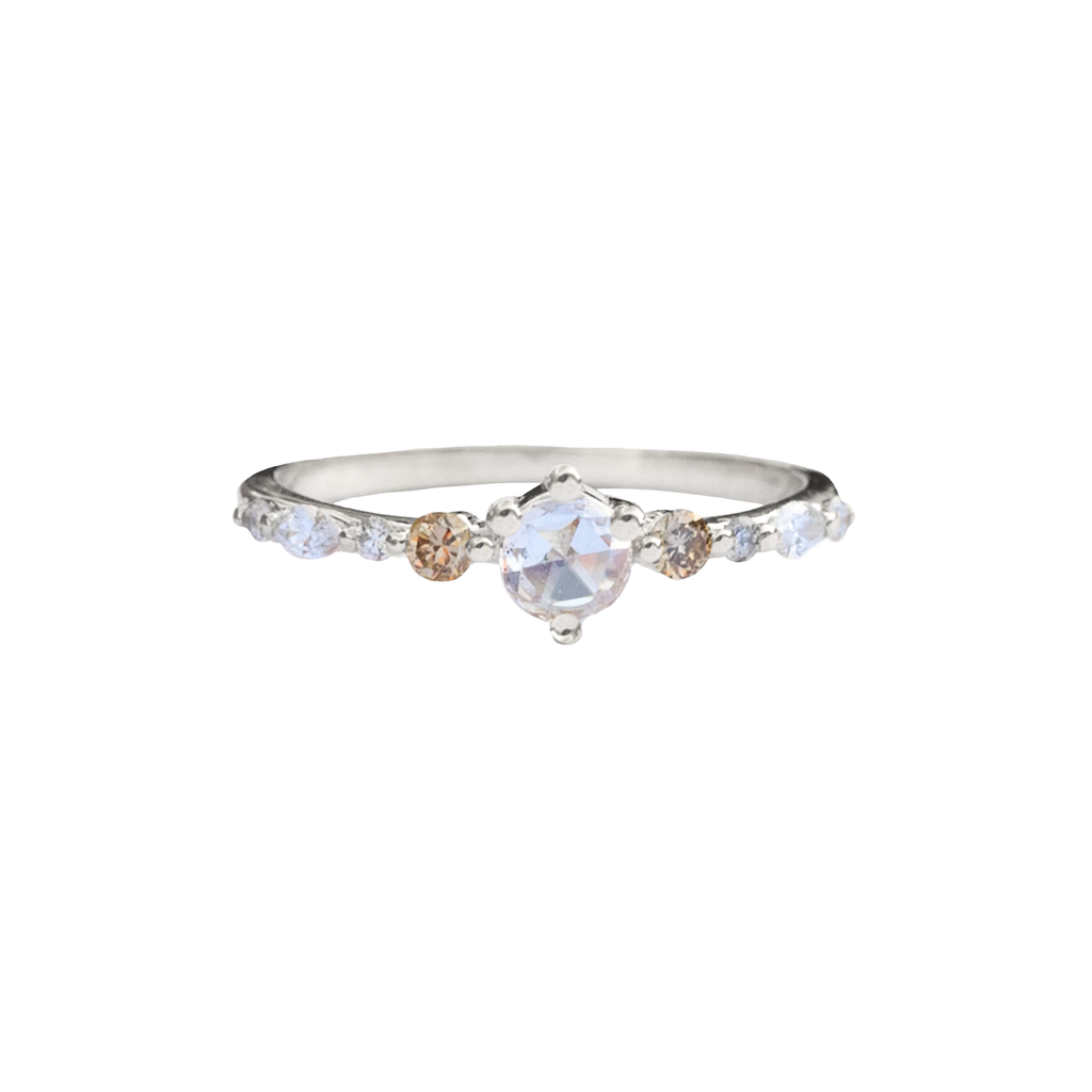 A twist on a classic solitaire engagement ring, featuring a round rose cut diamond, set with four prongs. The main diamond sits on maquise and round brilliant cut diamond band. Made in 14k or 18k white gold.
