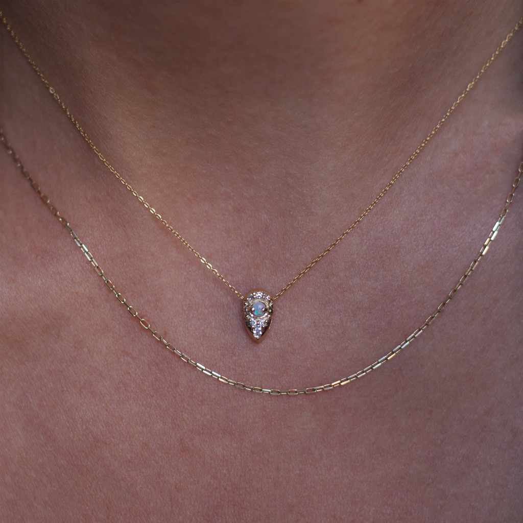 Little gold seed charm, featuring a round opal encrusted with round and marquise diamonds. Made in 14k gold. 