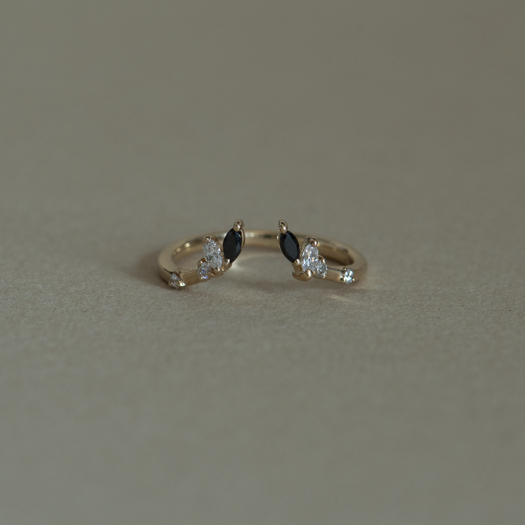 An open black and white diamond crown wedding band with a gentle wave to trace and pair with any engagement ring, whether it’s a solitaire or a halo. This ring is also a perfect everyday stackable ring that can be stacked with your favourite everyday staples, or worn on its own. Made in 14K or 18K yellow gold.