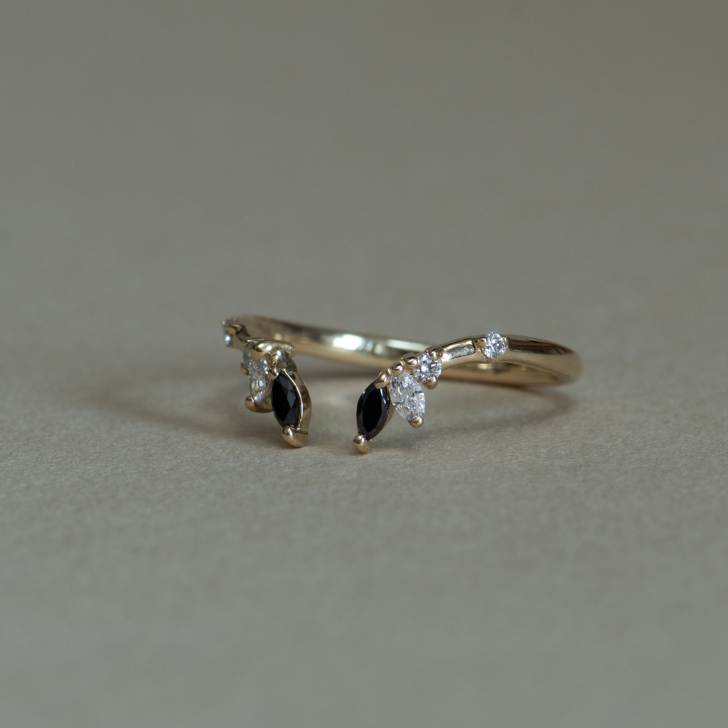 An open black and white diamond crown wedding band with a gentle wave to trace and pair with any engagement ring, whether it’s a solitaire or a halo. This ring is also a perfect everyday stackable ring that can be stacked with your favourite everyday staples, or worn on its own. Made in 14K or 18K gold.